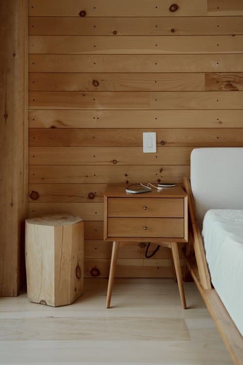 Bedroom with wood-paneled wall and river outlook