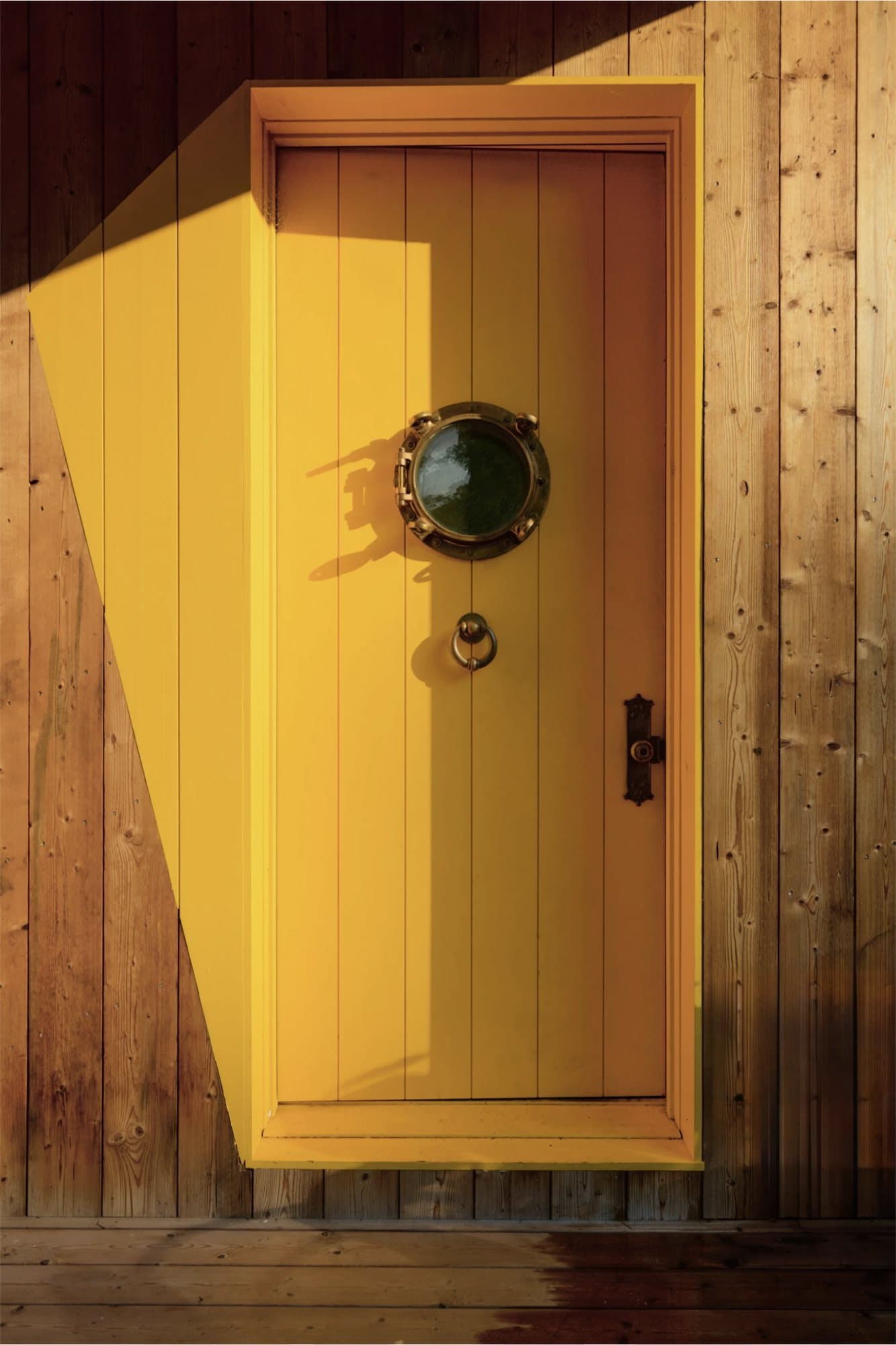Signature yellow entry door with porthole detail