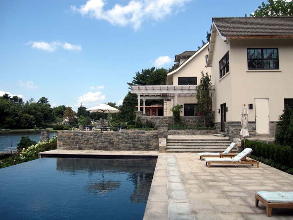 The renovated white estate seen from the manicured lawn