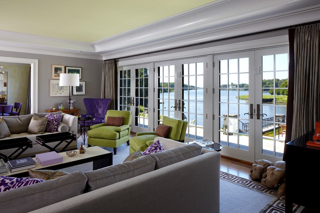 Living room opening through French doors to the water