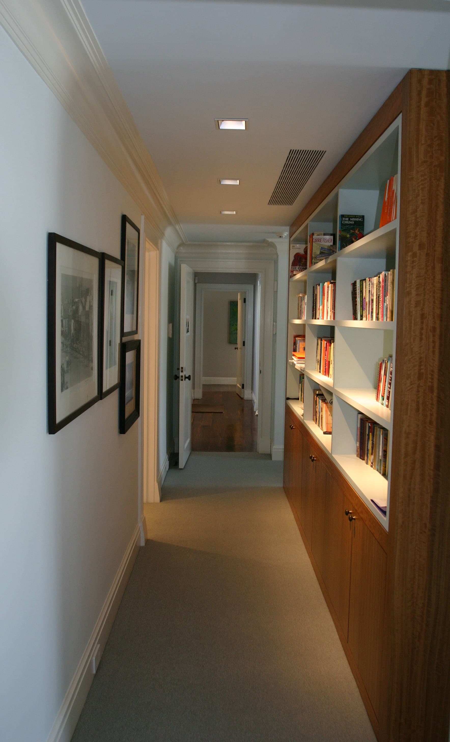 Master suite hall lined with built-in bookshelves