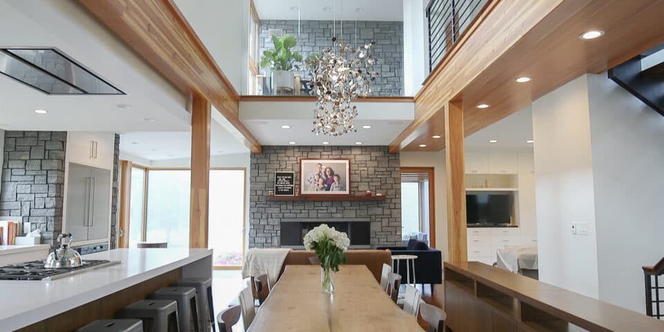 Double-height great room with exposed timber and stone fireplace