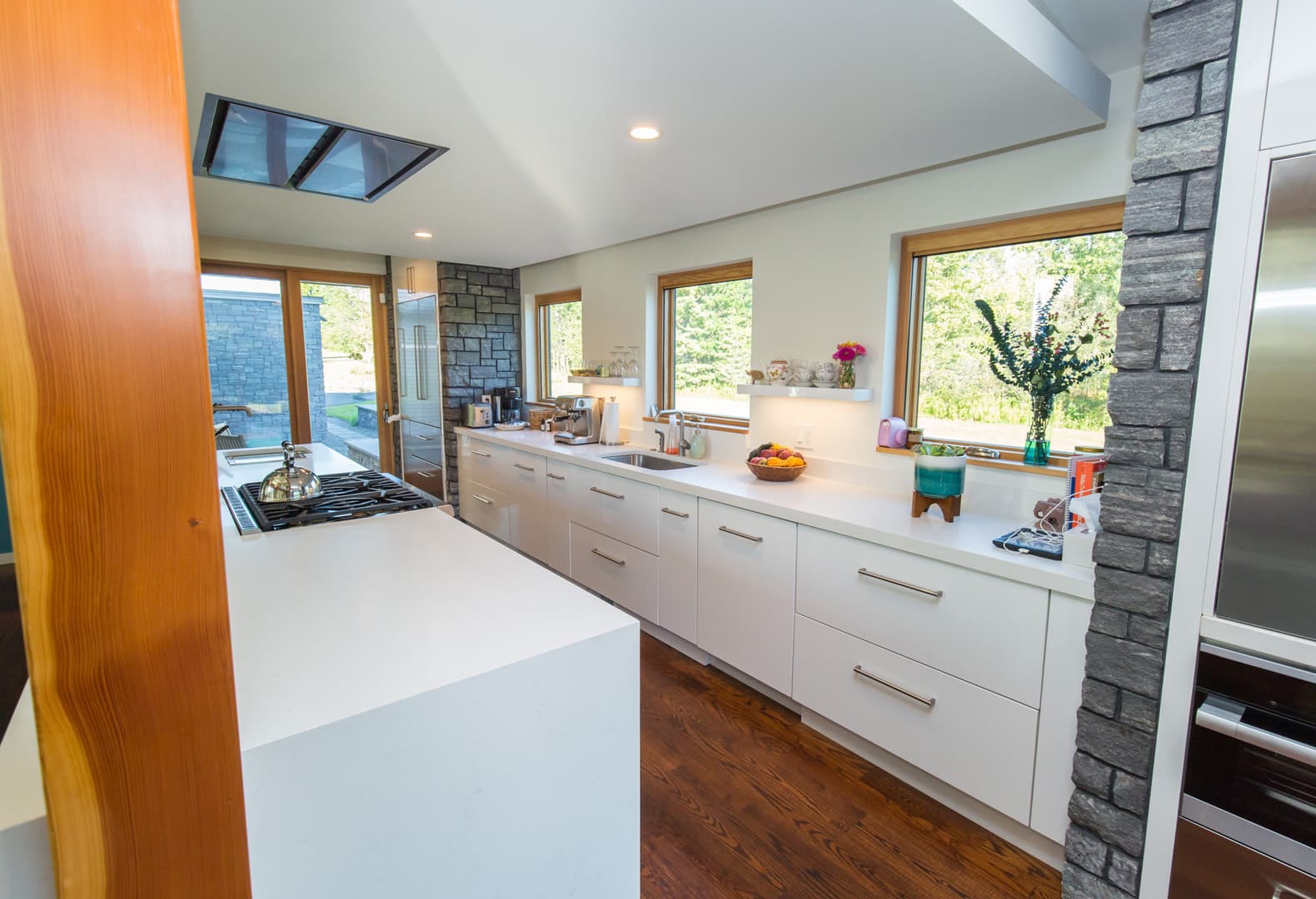 White kitchen with stone accents and views to the landscape