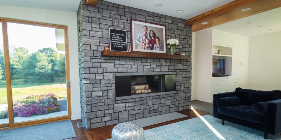 Living room anchored by a full-height stone fireplace