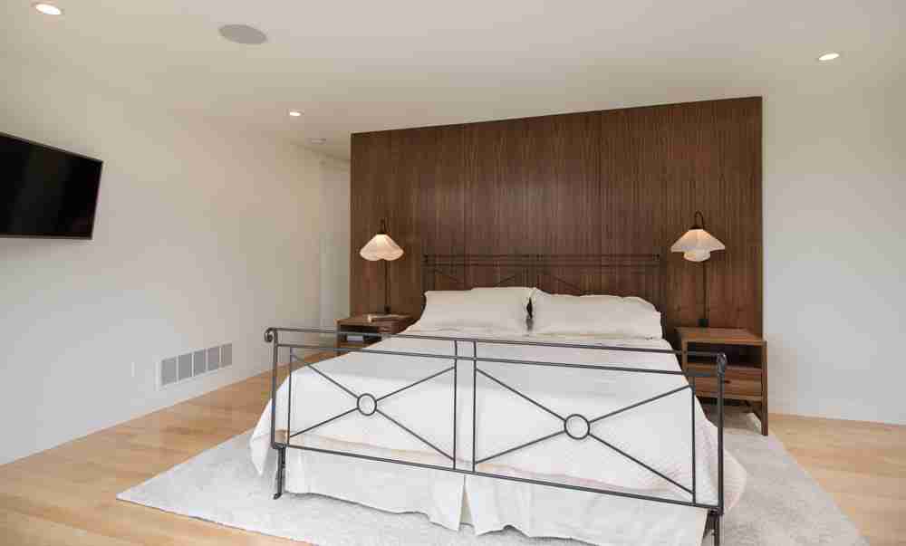 Primary bedroom with walnut feature wall