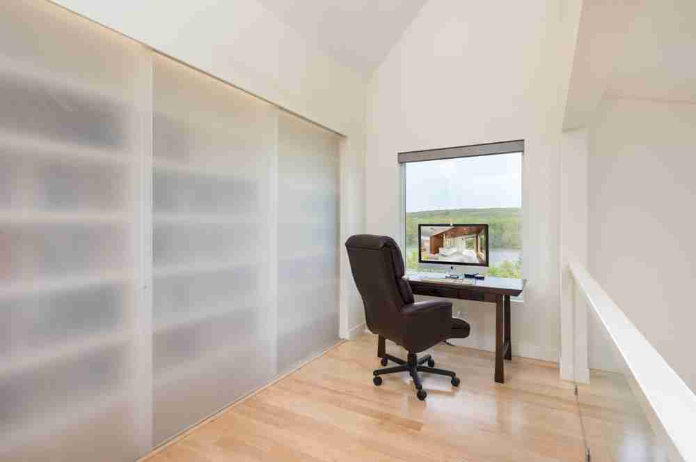Loft office with translucent sliding panels overlooking the living space